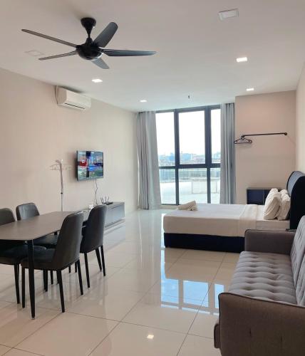 a bedroom with a bed and a table and a couch at Atria Sofo Suites - Petaling Jaya in Petaling Jaya