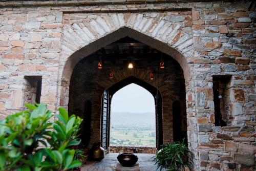 an archway in a stone building with a window at Fort Dadhikar, Alwar in Alwar