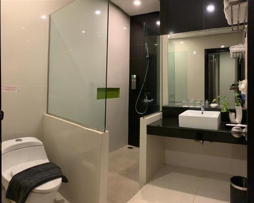 een badkamer met een toilet, een wastafel en een douche bij Savana Hotel & Convention Malang in Malang