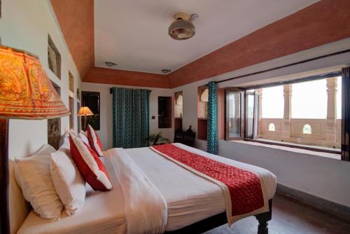 a bedroom with a large bed and a window at Fort Dadhikar, Alwar in Alwar