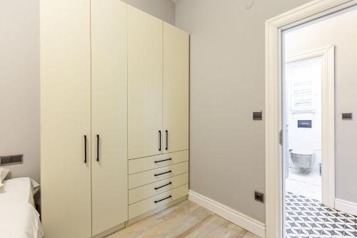 a bedroom with white cabinets and a door leading to a bathroom at Cozy Flat with Central Location in Moda Kadikoy in Istanbul