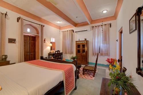 a bedroom with a bed and a living room at Fort Dadhikar, Alwar in Alwar
