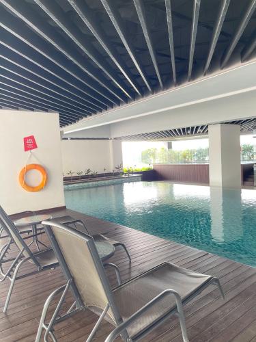 a swimming pool with chairs in a building at Atria Sofo Suites - Petaling Jaya in Petaling Jaya