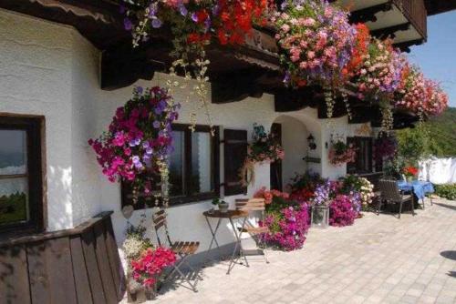 a building with lots of flowers hanging from it at Hof Rossruck in Fischbachau