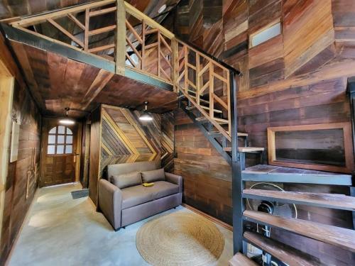 a living room with a staircase and a couch at ไชยพล โฮมสเตย์ หมู่บ้านแม่กำปอง in Ban Pok Nai