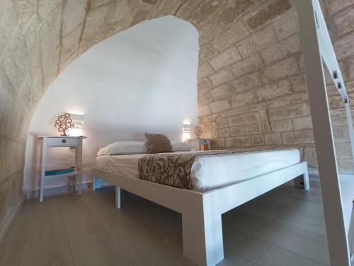 a bedroom with a bed and a stone wall at Ventidue Venti in Bari