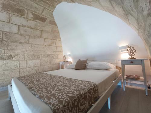 1 dormitorio con cama y pared de piedra en Ventidue Venti, en Bari