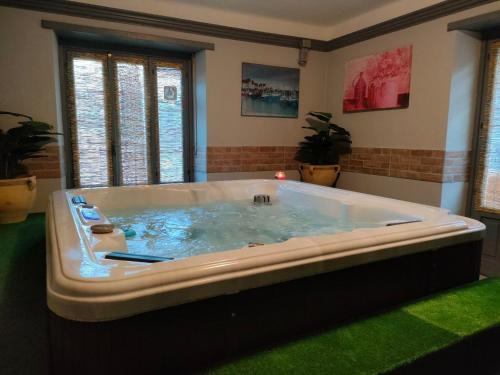 una grande vasca da bagno in una stanza con erba verde di Hotel Lion a Roure Turin