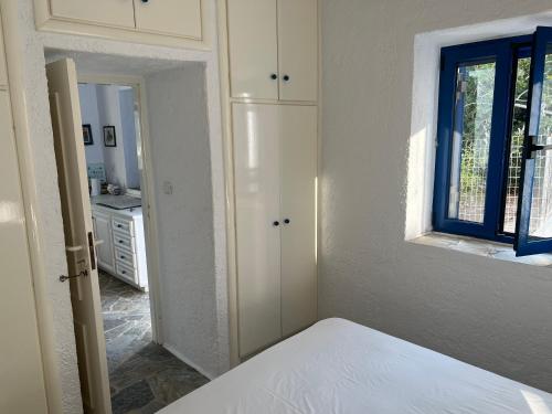 a white bedroom with a bed and a window at Aegean Dream 3 in Agia Marina