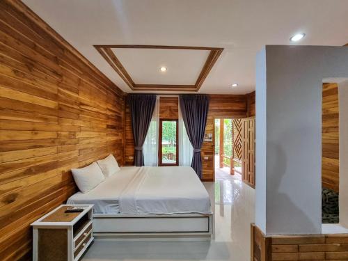 1 dormitorio con 1 cama y paredes de madera en Phuvara Boutique Aonang, en Ao Nang Beach