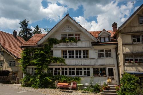 an old house with chairs and tables in front of it at Gasthaus Rössli in Trogen