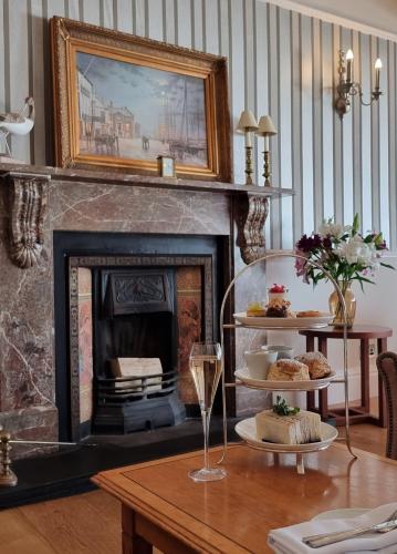 a living room with a fireplace and a table with cakes at Watersmeet Hotel in Woolacombe