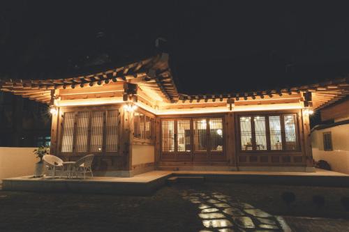 a house with two chairs in front of it at night at Gyeongju Hanok Sohwa in Gyeongju
