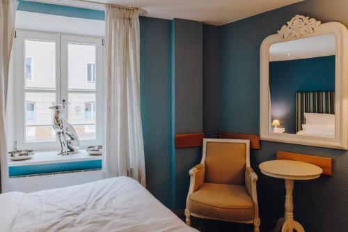 雷根斯堡的住宿－Little 7 - Boutique Hotel，一间卧室配有一张床、一把椅子和镜子