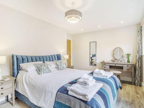 1 dormitorio con 1 cama con toallas en Wisteria Lodge - Ukc5804 en Shelfanger