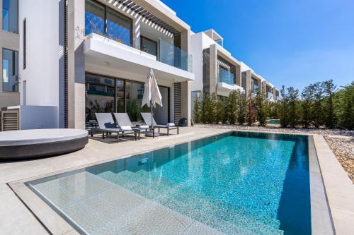 a swimming pool in front of a house at Cyan 3-Bedroom Villa in Protaras in Paralimni