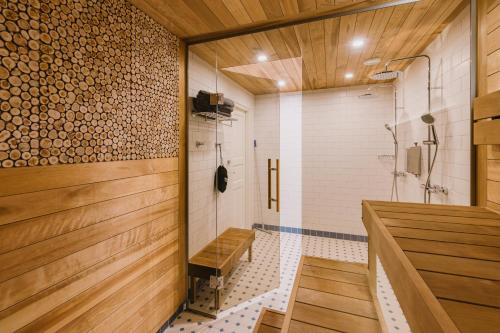 La salle de bains est pourvue d'une douche et de murs en bois. dans l'établissement Villa Fannyhof, à Haapsalu