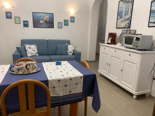 - un salon avec un canapé bleu et une table dans l'établissement Flaviana Salento Holiday House, à Pulsano