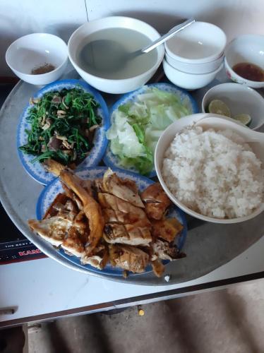 une plaque de nourriture avec du riz et des légumes sur une table dans l'établissement Má Si H'MÔNG HOMESTAY Tả Phìn, à Sa Pa