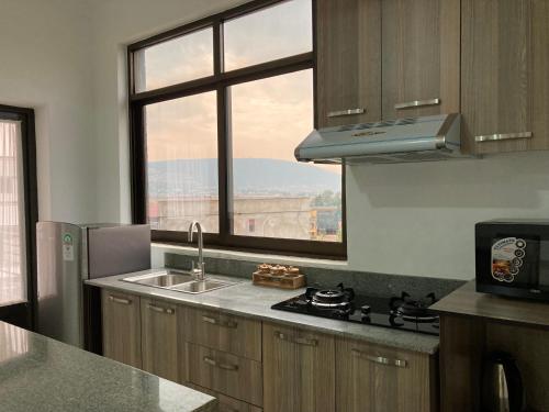 een keuken met een wastafel en een raam bij Rebero View Apartments in Kigali