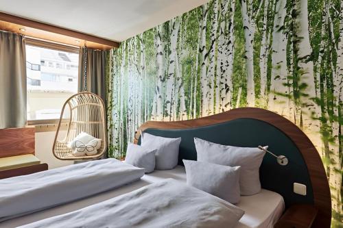 sypialnia z łóżkiem i ścianą z drzewami w obiekcie Cocoon Stachus w Monachium
