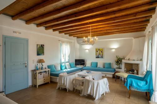 uma sala de estar com mobiliário azul e um tecto de madeira em Irilena's guest house em Faros