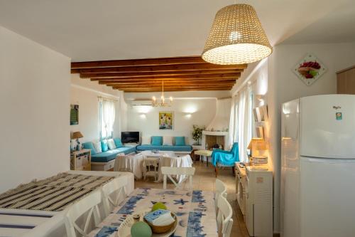 uma sala de estar com mobiliário azul e uma cozinha em Irilena's guest house em Faros