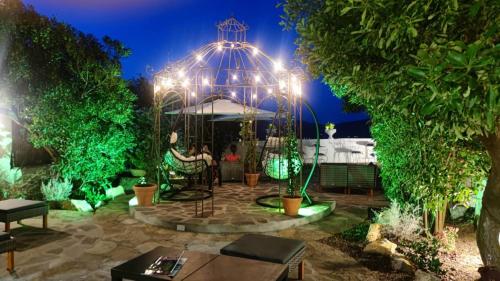 a garden at night with a table and chairs at Hotel Golfo Azzurro in Capoliveri