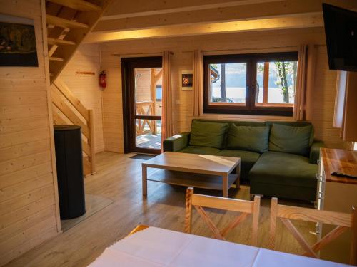 a living room with a green couch and a table at Ośrodek Wypoczynkowy Laguna in Lubniewice