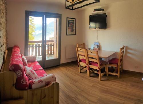 uma sala de estar com um sofá, uma mesa e uma televisão em Appartement Saint Gervais les Bains vue imprenable Mont Blanc em Saint-Gervais-les-Bains