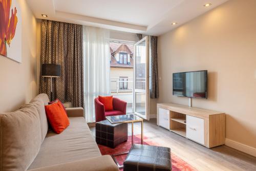 a living room with a couch and a television at Silver Crown Hotel & Residence, Palace Quarter in Budapest