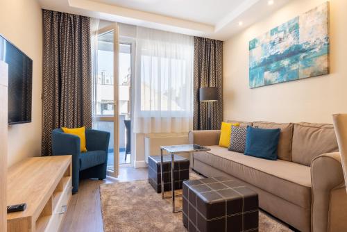 ein Wohnzimmer mit einem Sofa und einem Tisch in der Unterkunft Silver Crown Hotel & Residence, Palace Quarter in Budapest