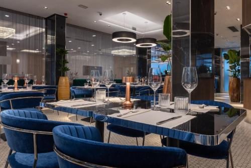 a restaurant with blue chairs and tables at Silver Crown Hotel & Residence, Palace Quarter in Budapest