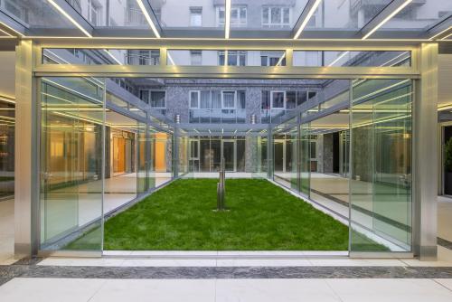 a glass extension of a building with a garden in the middle at Silver Crown Hotel & Residence, Palace Quarter in Budapest