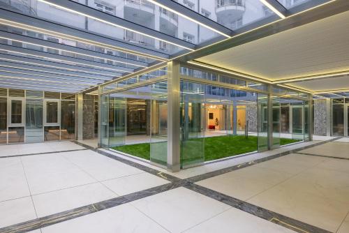 an office building with glass doors and a courtyard at Silver Crown Hotel & Residence, Palace Quarter in Budapest