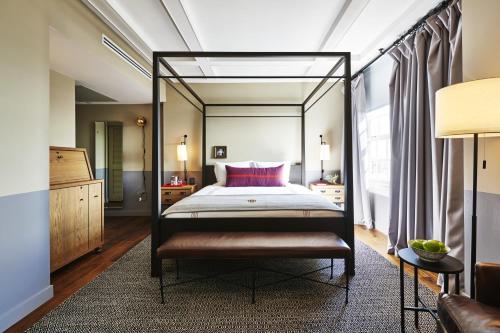 a bedroom with a canopy bed and a couch at The Hollywood Roosevelt in Los Angeles