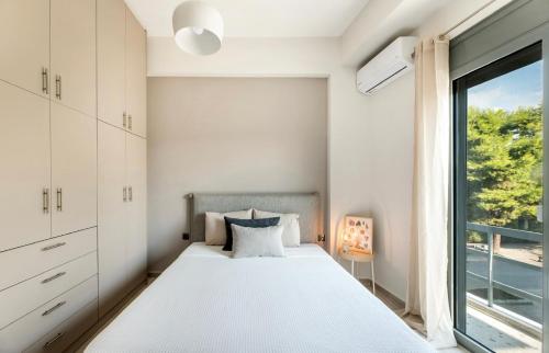 a bedroom with a bed and a window at Eleusis Suites Β in Eleusis