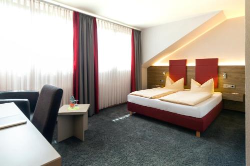 a hotel room with a bed and a chair at Hotel-Restaurant Bierhäusle in Freiburg im Breisgau