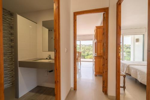 baño con lavabo, cama y espejo en Apartamentos Costamar, en Lloret de Mar