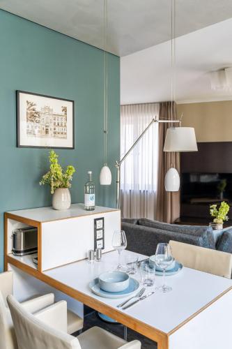 a living room with a dining room table with chairs at The Green Rostock Apartment Hotel in Rostock