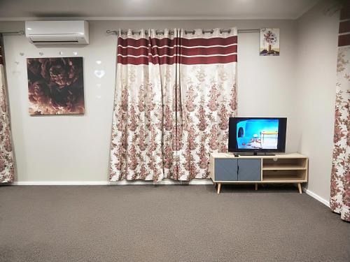 ein Wohnzimmer mit einem TV und einer amerikanischen Flagge in der Unterkunft Trentham Gem in Upper Hutt