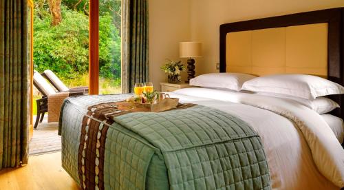 a bedroom with a large bed with a table on it at The Woodland Villas at Parknasilla Resort in Sneem