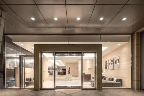 a large glass door in a building with a couch at Lakeshore Hotel Metropolis in Hsinchu City