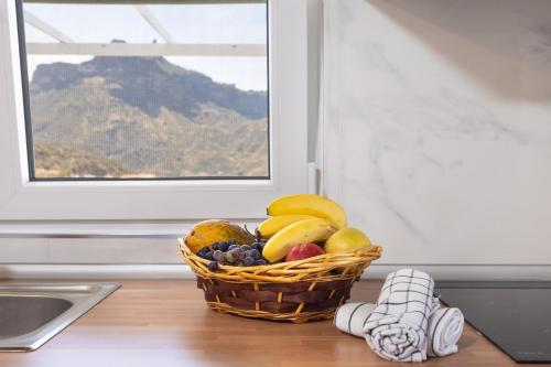a basket of fruit on a counter next to a window at Casa Isabela with Roque Nublo view in Tejeda