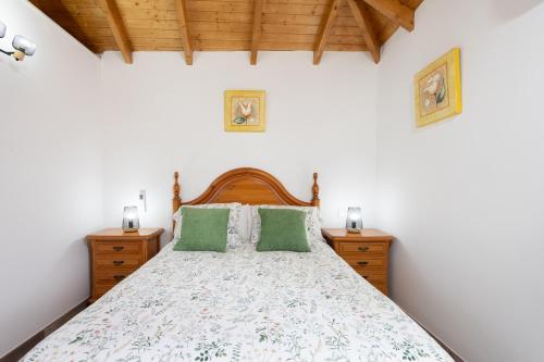 a bedroom with a large bed with green pillows at Casa Isabela with Roque Nublo view in Tejeda