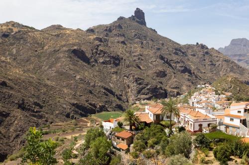 a village on a hill with mountains in the background at Casa Isabela with Roque Nublo view in Tejeda