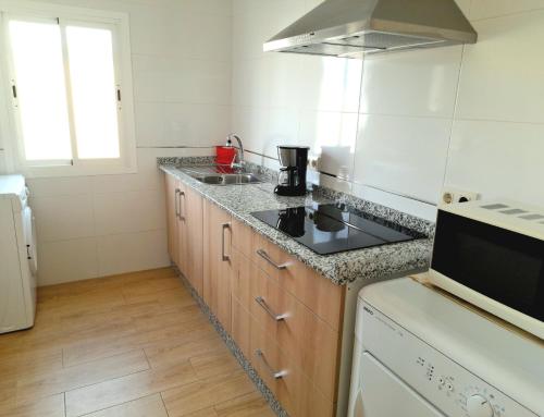 a kitchen with a stove and a counter top at Piso La Buganvilla in Bailén