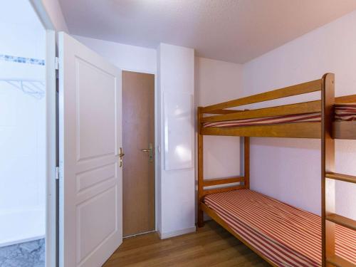 Cette petite chambre comprend 2 lits superposés et une porte. dans l'établissement Studio cabine, piscine couverte et fitness, parking, proche pistes, calme, terrasse exposée sud - FR-1-404-302, à La Mongie
