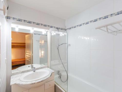 une salle de bain blanche avec un lavabo et une douche dans l'établissement Studio cabine, piscine couverte et fitness, parking, proche pistes, calme, terrasse exposée sud - FR-1-404-302, à La Mongie