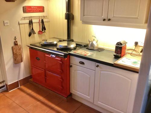 a kitchen with a red and white stove top oven at Minty Cottage in Hythe
